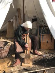 Photo of a medieval style fletcher sitting in a tent